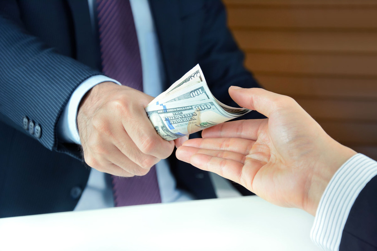 Businessman handing cash to another man